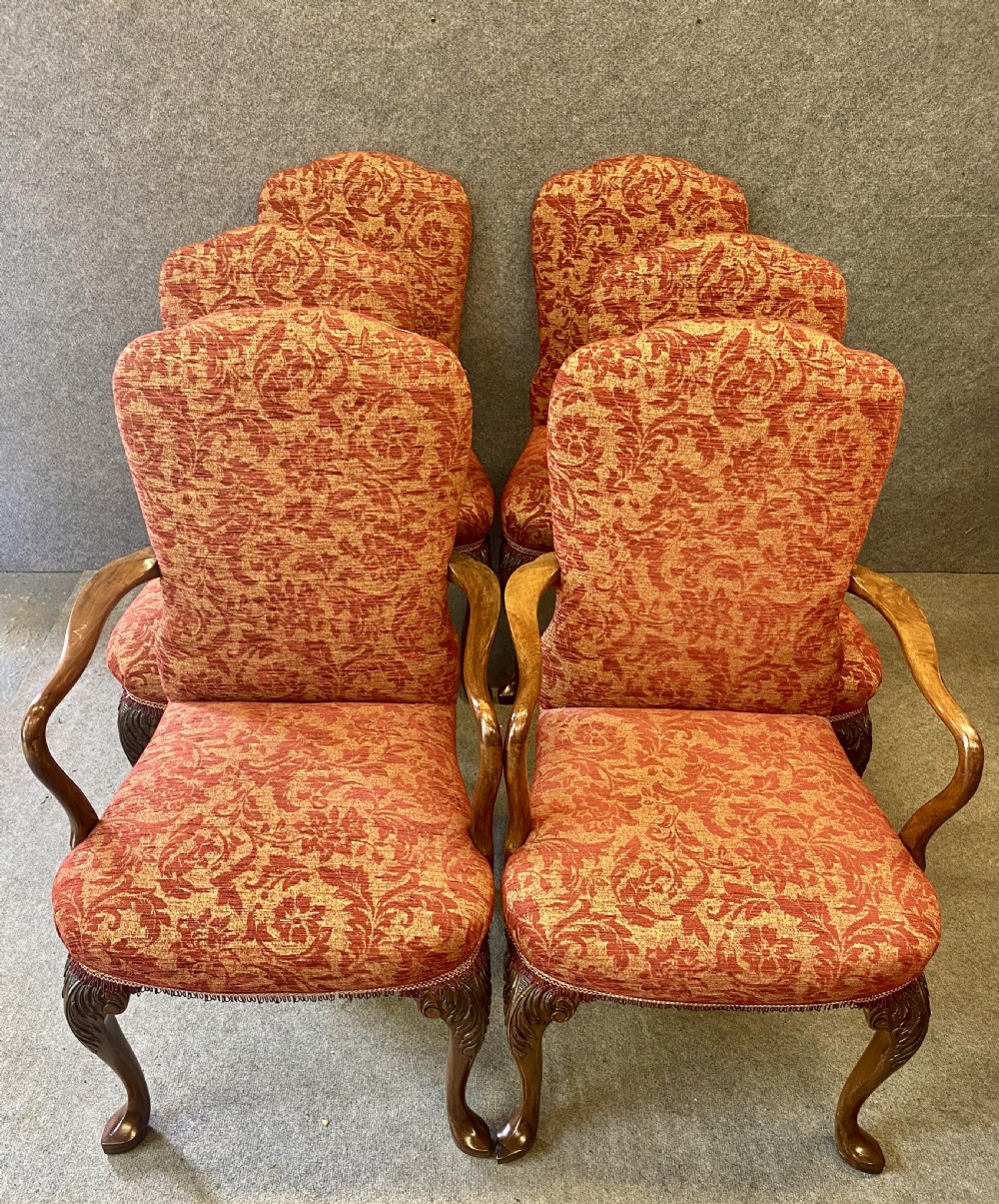 A nine-piece Queen Anne style dining room suite featuring a burr walnut dining table, matching sideboards, and red patterned fabric chairs with cabriole legs. View XII