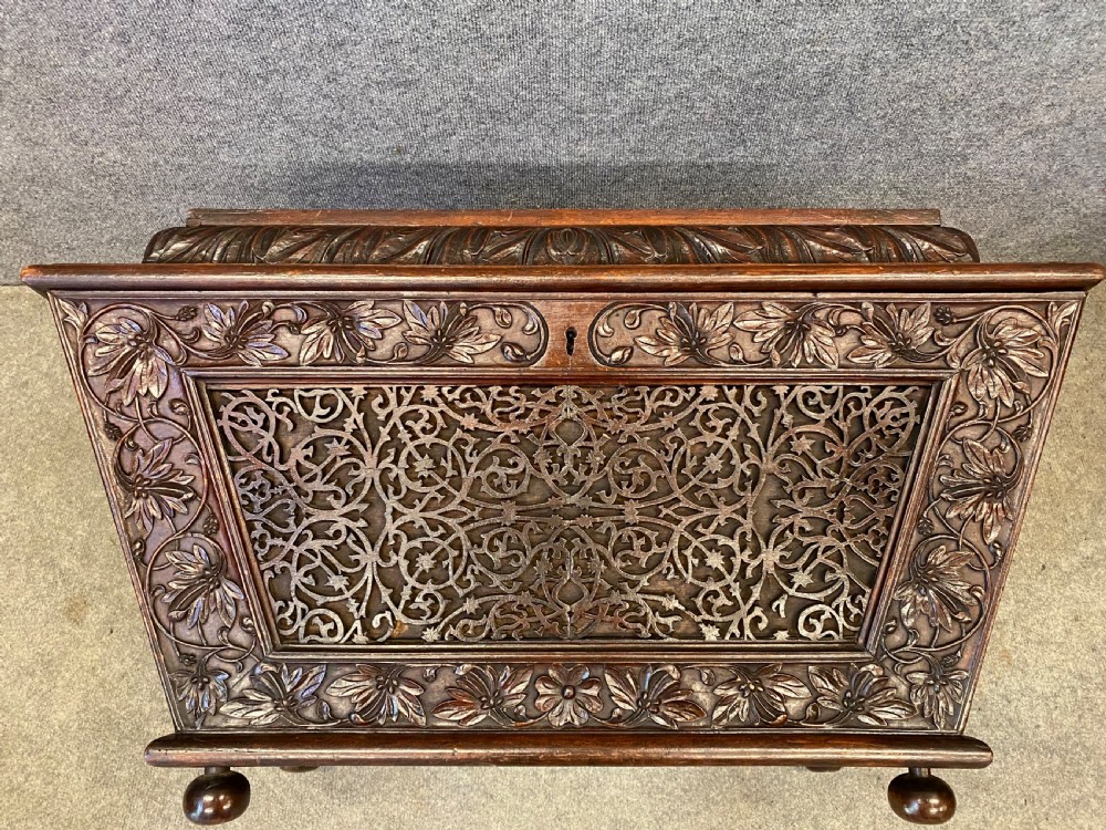 A dark hardwood Anglo-Indian carved cellarette featuring detailed floral latticework, a sarcophagus lid, and small ball feet. View II