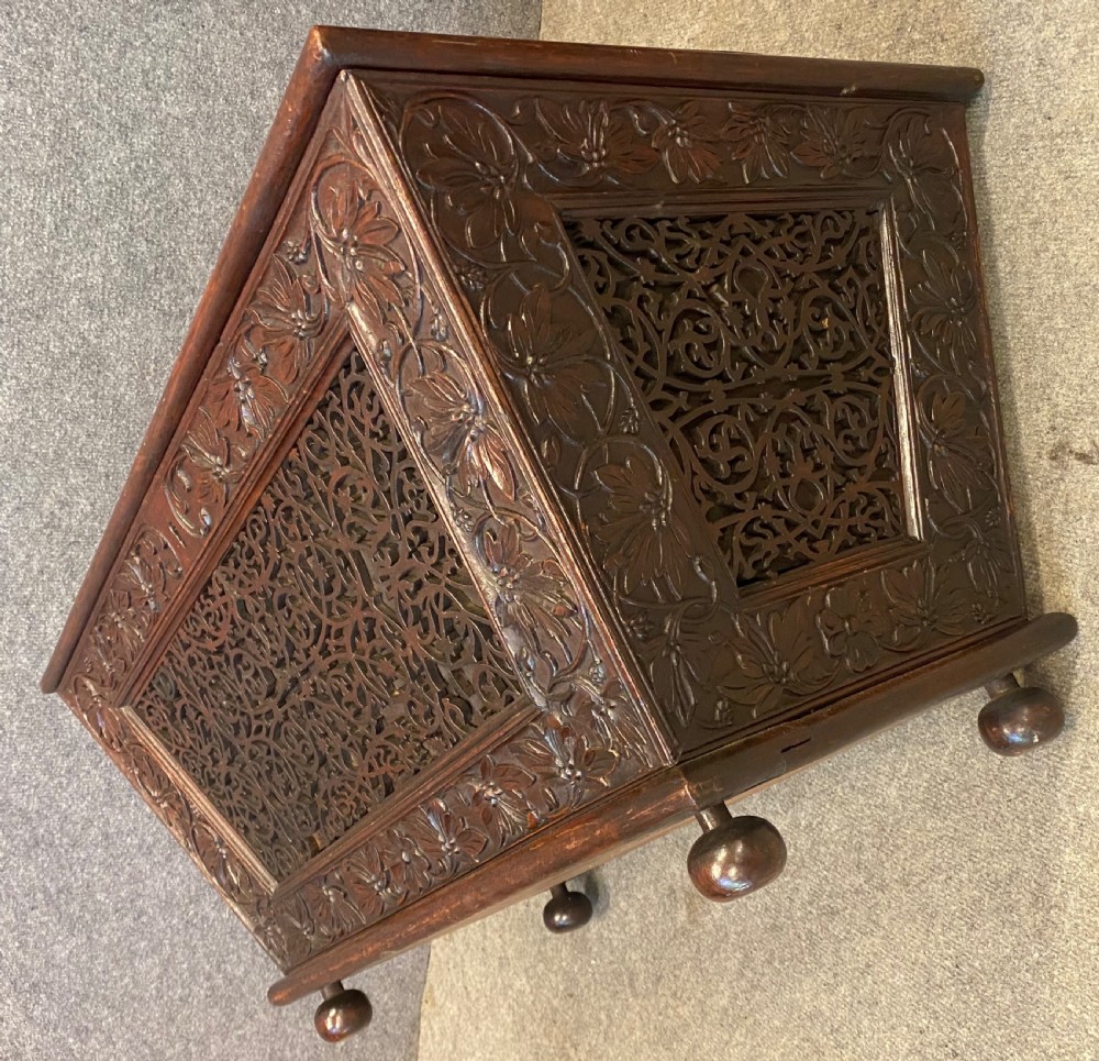 A dark hardwood Anglo-Indian carved cellarette featuring detailed floral latticework, a sarcophagus lid, and small ball feet. View VII
