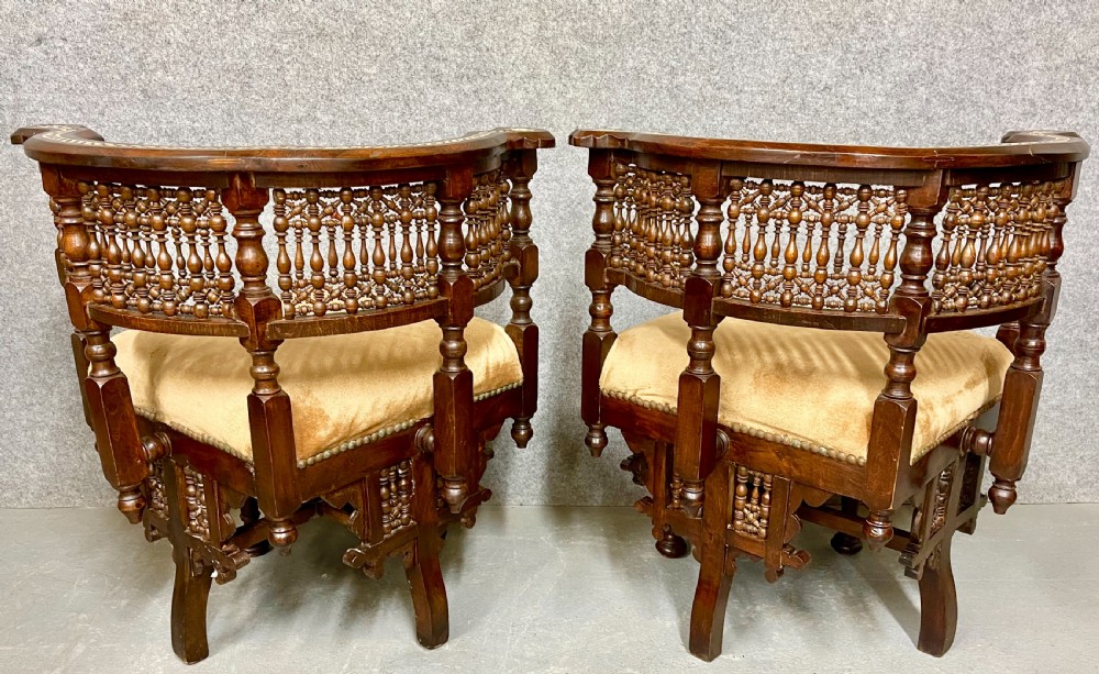 A dark hardwood Moorish Revival seating suite consisting of an S-shaped central conversation seat flanked by two corner armchairs, embellished with lathe-turned spindle lattice backs, geometric bone inlay, and mustard velvet seats. View V
