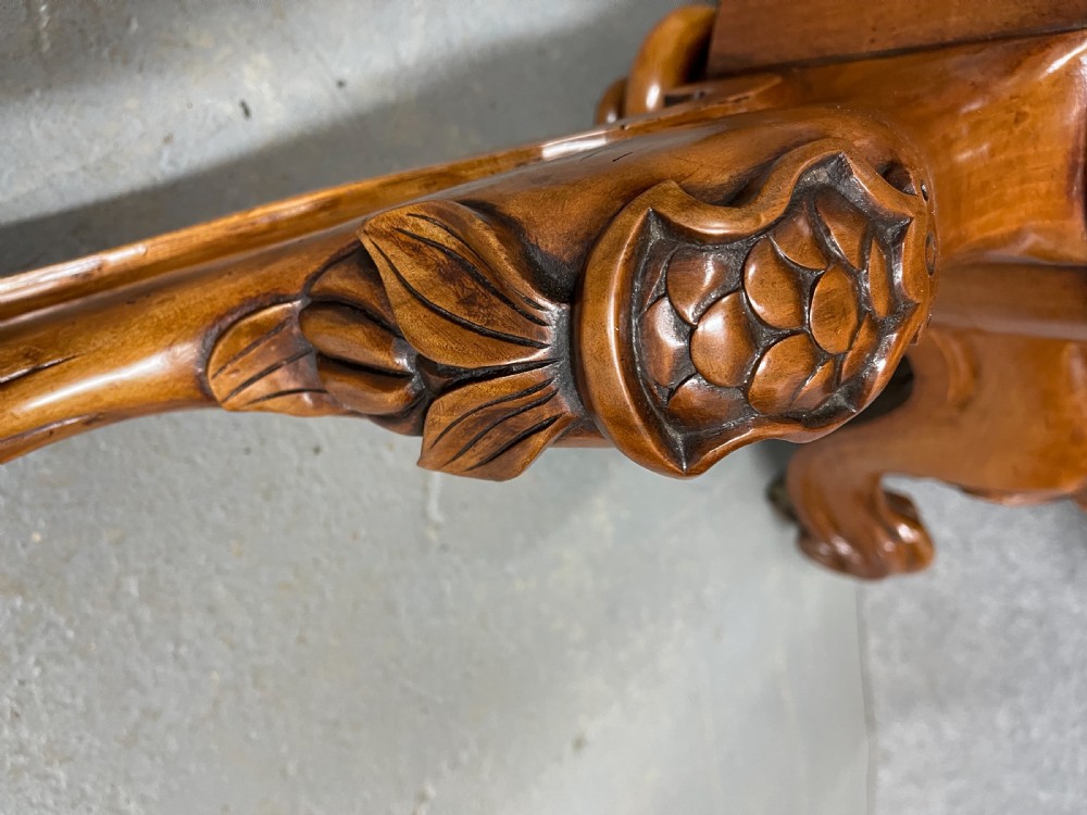 A circular Victorian burr walnut centre table featuring floral marquetry inlay on the top surface and supported by a carved pedestal base. View VII