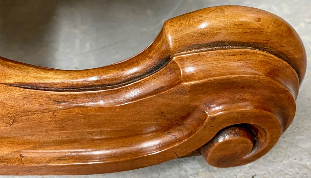A circular Victorian burr walnut centre table featuring floral marquetry inlay on the top surface and supported by a carved pedestal base. View IX