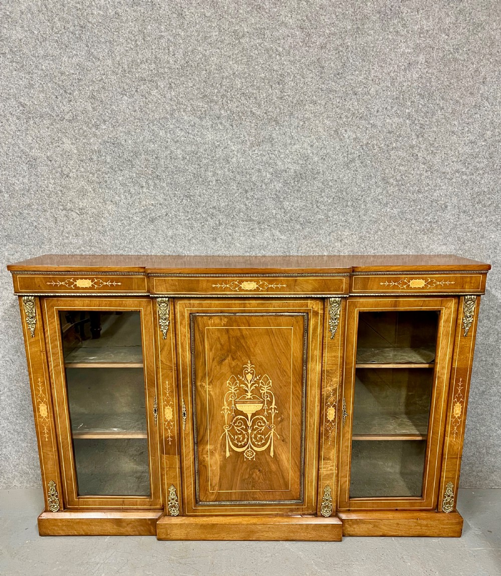 A Victorian warm brown walnut credenza featuring a central inlaid panel door flanked by two glazed display cabinet doors with gilt metal mounts. View II