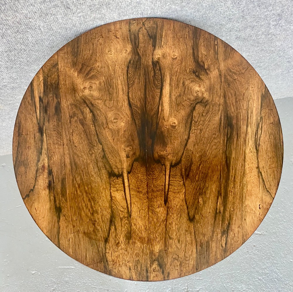 A three-tiered rosewood metamorphic table featuring circular graduated trays on a central column and a triform base with bun feet. View V