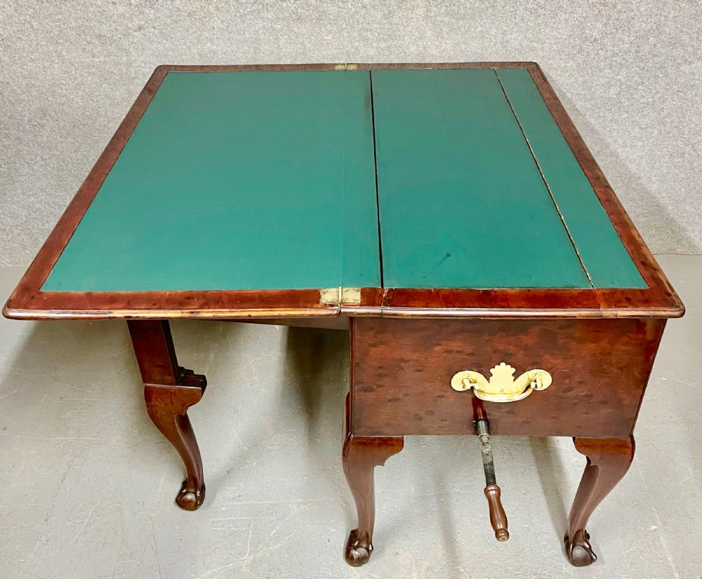 A George III mahogany metamorphic library table featuring a green leather writing surface, a fitted interior of small drawers, and cabriole legs ending in claw and ball feet. View V