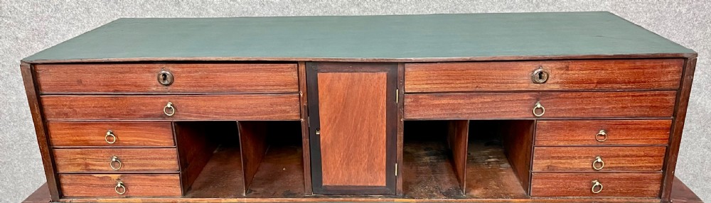 A George III mahogany metamorphic library table featuring a green leather writing surface, a fitted interior of small drawers, and cabriole legs ending in claw and ball feet. View XII