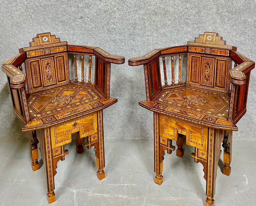A pair of antique Moorish corner armchairs featuring intricate geometric mother-of-pearl and bone inlay across walnut frames with spindle backrests. View III