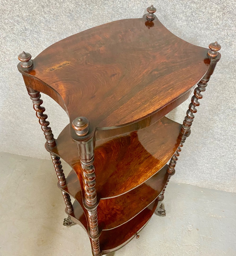 A four-tier dark rosewood whatnot featuring barley twist supports, a single base drawer, top corner finials, and brass castors. View VIII