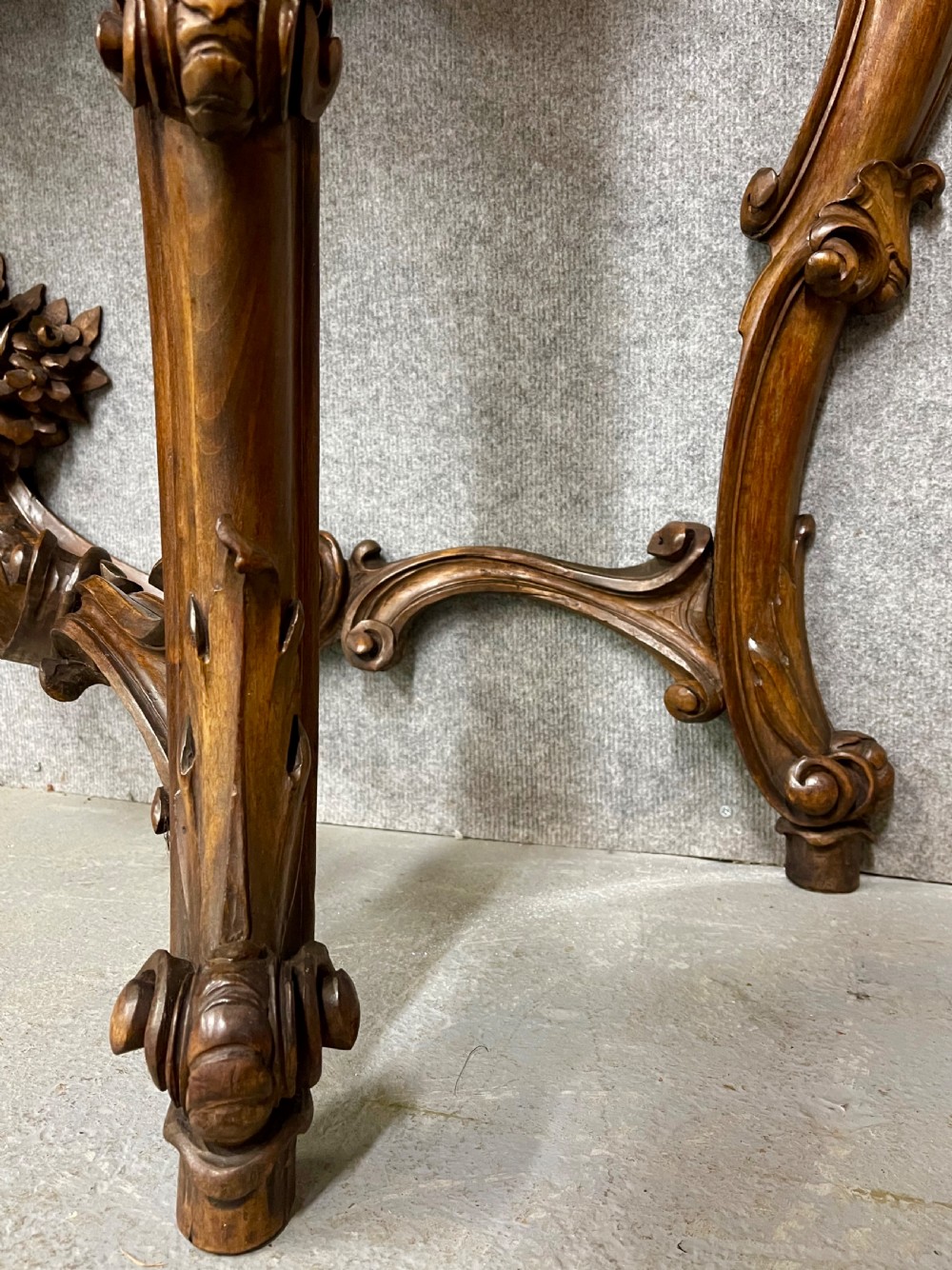 An intricately carved dark walnut console table featuring cabriole legs paired with a tall matching Rococo style arched wall mirror. View VIII