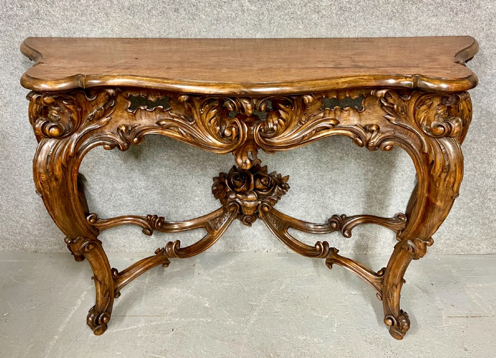 An intricately carved dark walnut console table featuring cabriole legs paired with a tall matching Rococo style arched wall mirror. View X