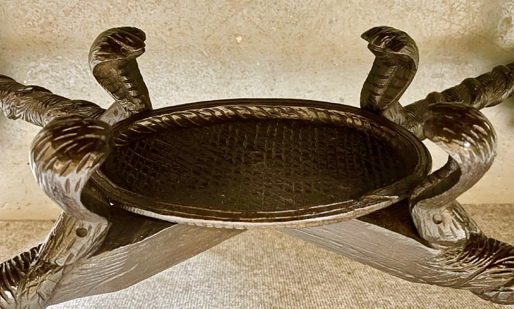 An oval Anglo-Indian dark wood centre table featuring an intricately carved floral border, a central radiating oval medallion, and legs sculpted as elephant heads with white tusks. View VII