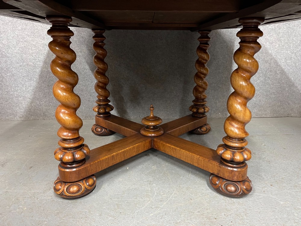 A Victorian octagonal walnut library table featuring spiral barley twist legs, a cross stretcher with a central finial, and open pull-out drawers. View II