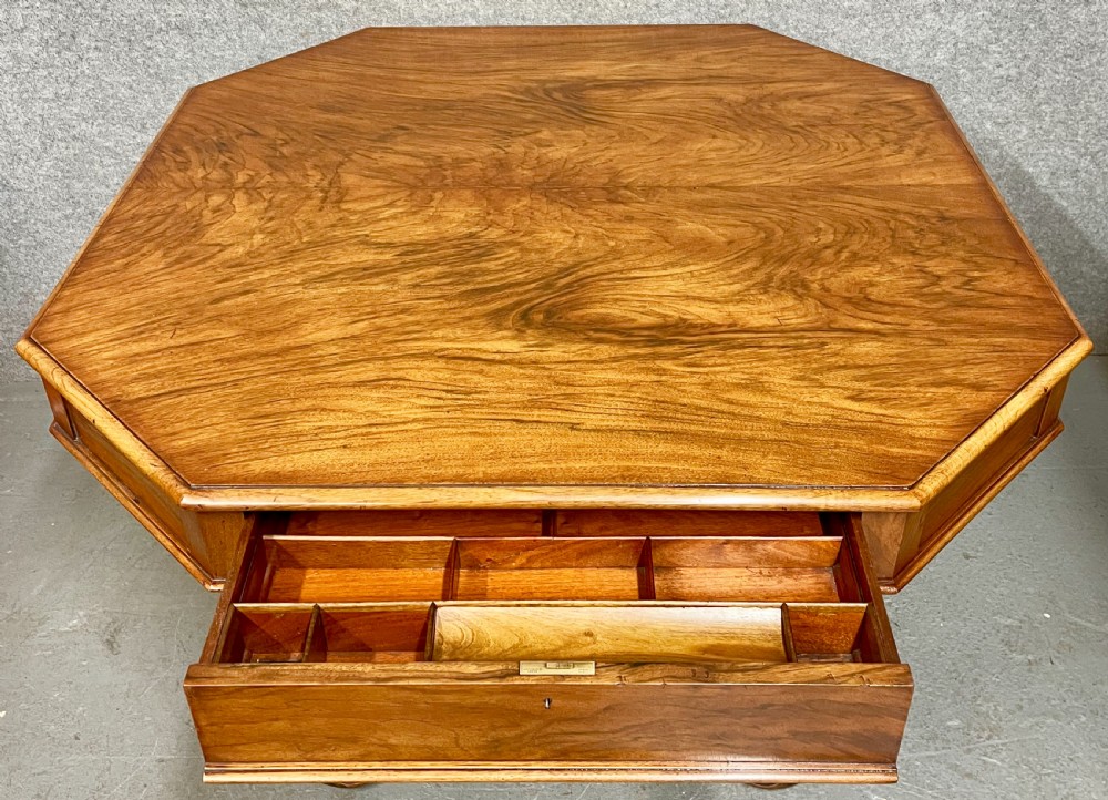 A Victorian octagonal walnut library table featuring spiral barley twist legs, a cross stretcher with a central finial, and open pull-out drawers. View VII