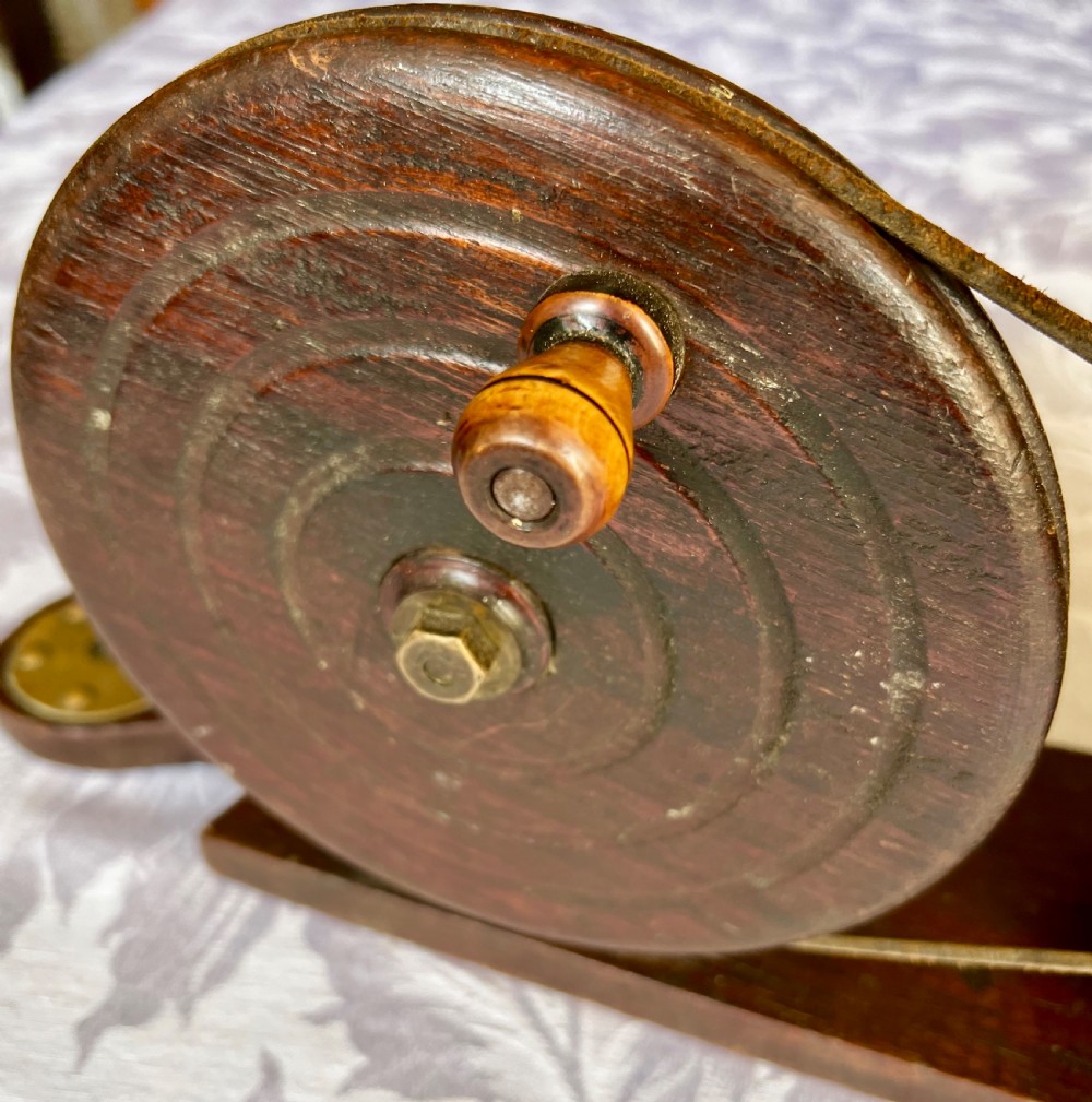 An antique mechanical rotary hearth bellows constructed from dark mahogany with a brass-trimmed cylinder housing, brass nozzle, and hand-crank pulley wheel. View IV