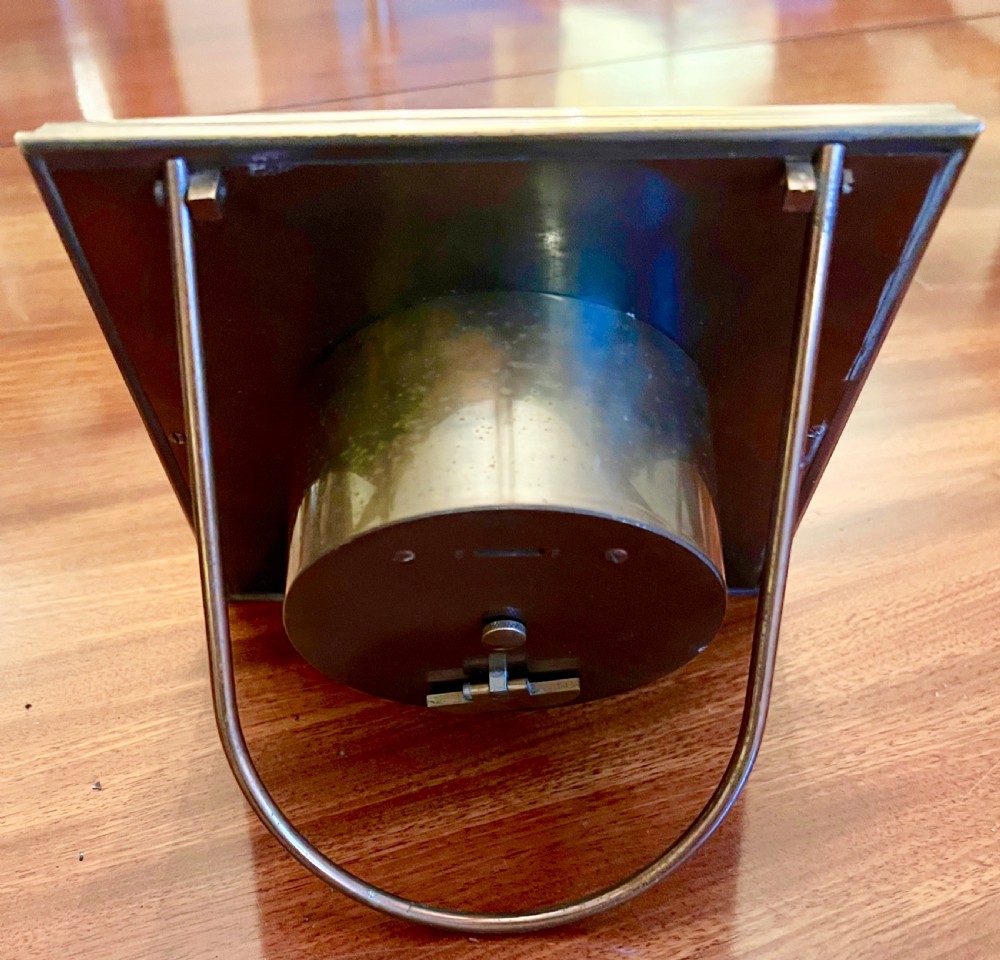 A square brass framed desk clock featuring a silvered chapter ring with Roman numerals, blued steel hands, and corner cherub spandrel accents. View IV
