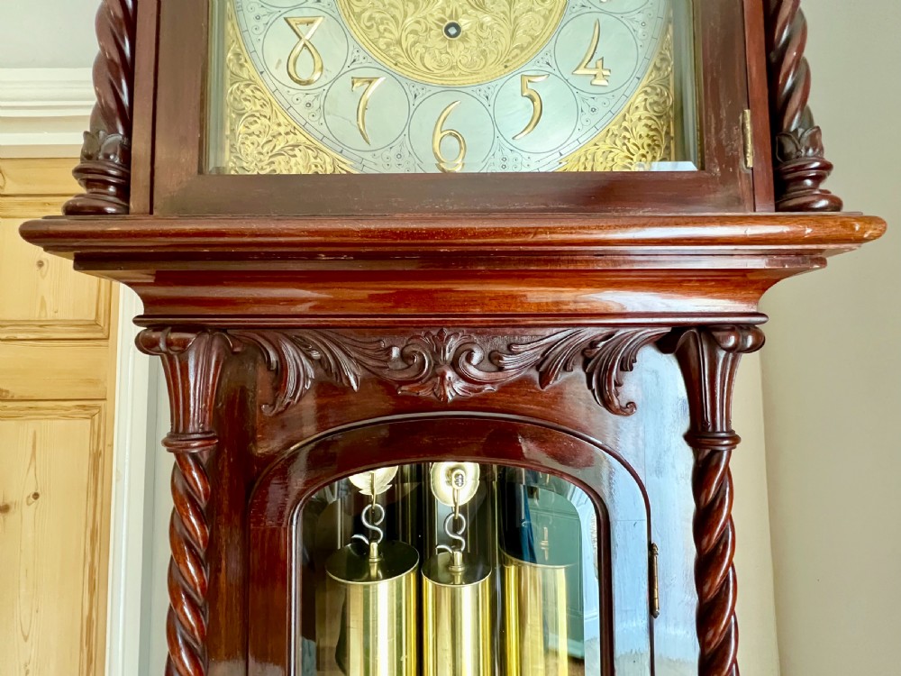 A tall Victorian carved mahogany musical longcase clock featuring spiral columns, a brass arch dial, visible brass weights, and tubular chimes behind a glass door. View XIII