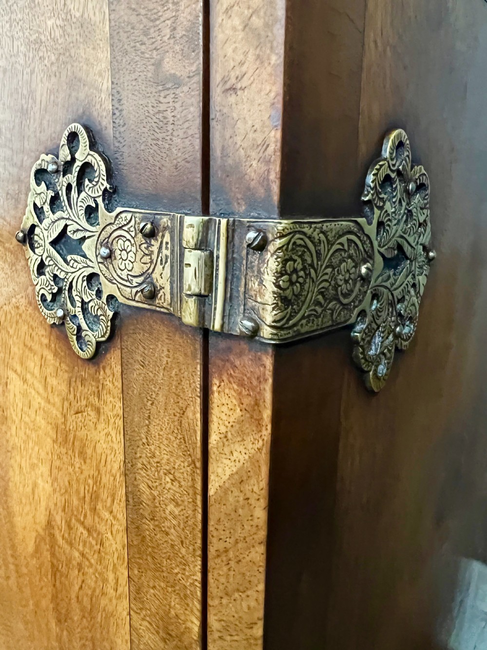 A William and Mary style burr walnut cocktail cabinet on stand featuring engraved brass strap hinges, double doors, a single drawer, turned legs, and a shaped stretcher. View VI