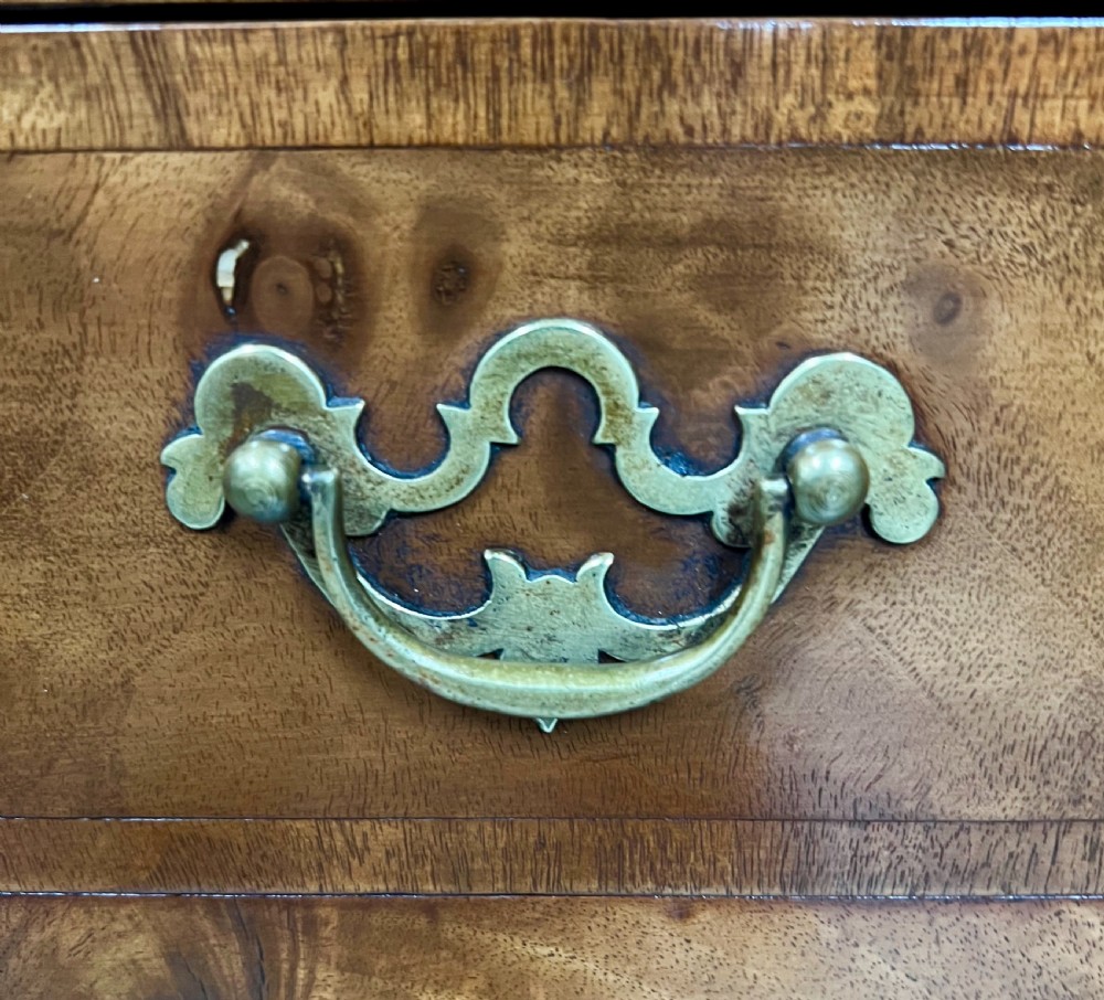 A William and Mary style burr walnut cocktail cabinet on stand featuring engraved brass strap hinges, double doors, a single drawer, turned legs, and a shaped stretcher. View VIII