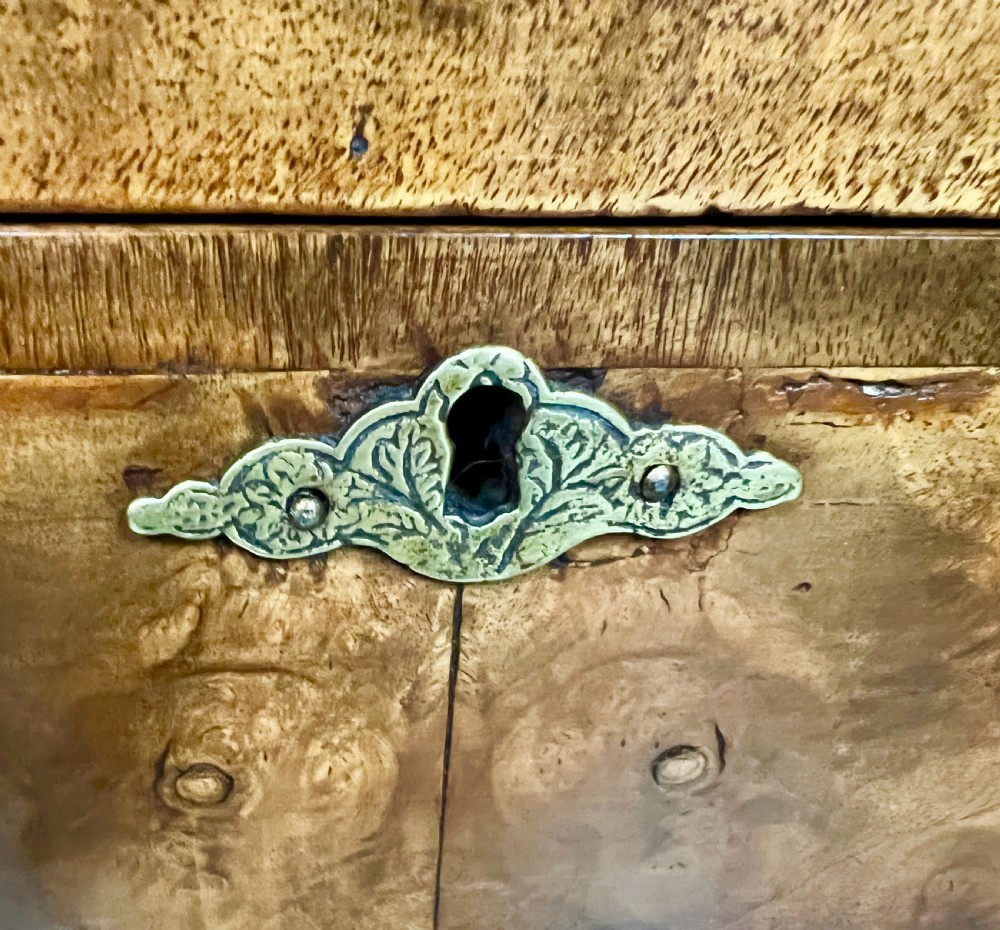 A William and Mary style burr walnut cocktail cabinet on stand featuring engraved brass strap hinges, double doors, a single drawer, turned legs, and a shaped stretcher. View XI