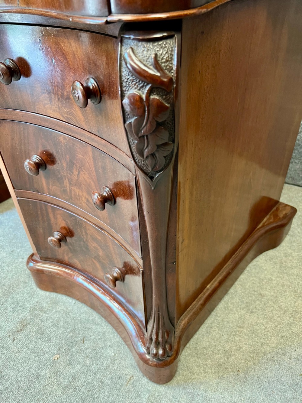 A Victorian figured mahogany pedestal desk featuring a shaped gilded leather surface, serpentine drawer fronts, and turned wooden knobs. View VIII