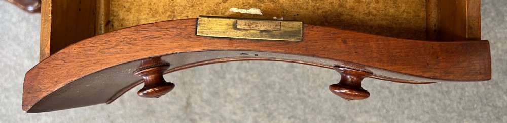 A Victorian figured mahogany pedestal desk featuring a shaped gilded leather surface, serpentine drawer fronts, and turned wooden knobs. View IX