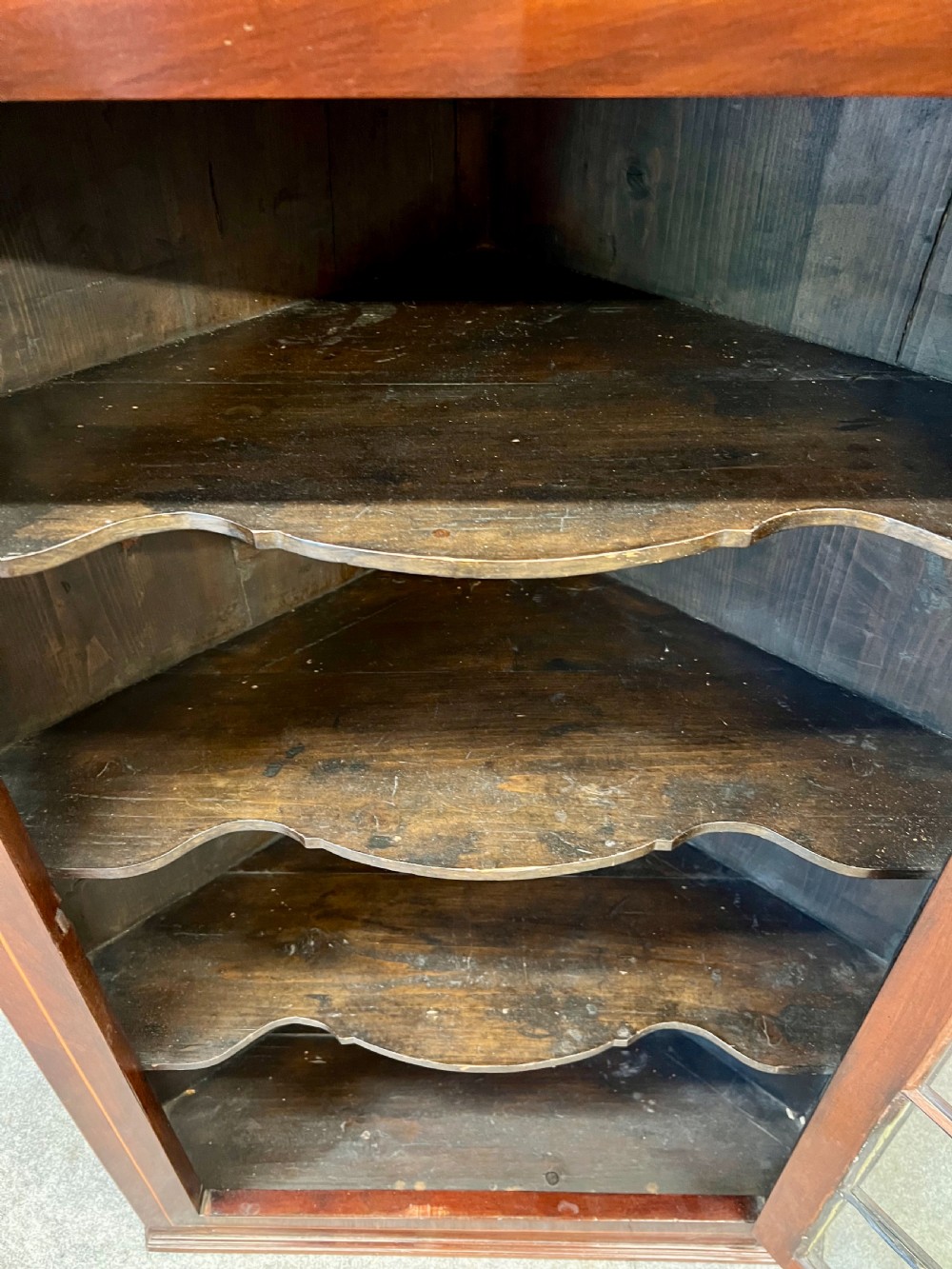 A George III hanging corner cupboard made of dark mahogany, featuring an astragal glazed door and decorative geometric inlay along the upper frieze. View VIII