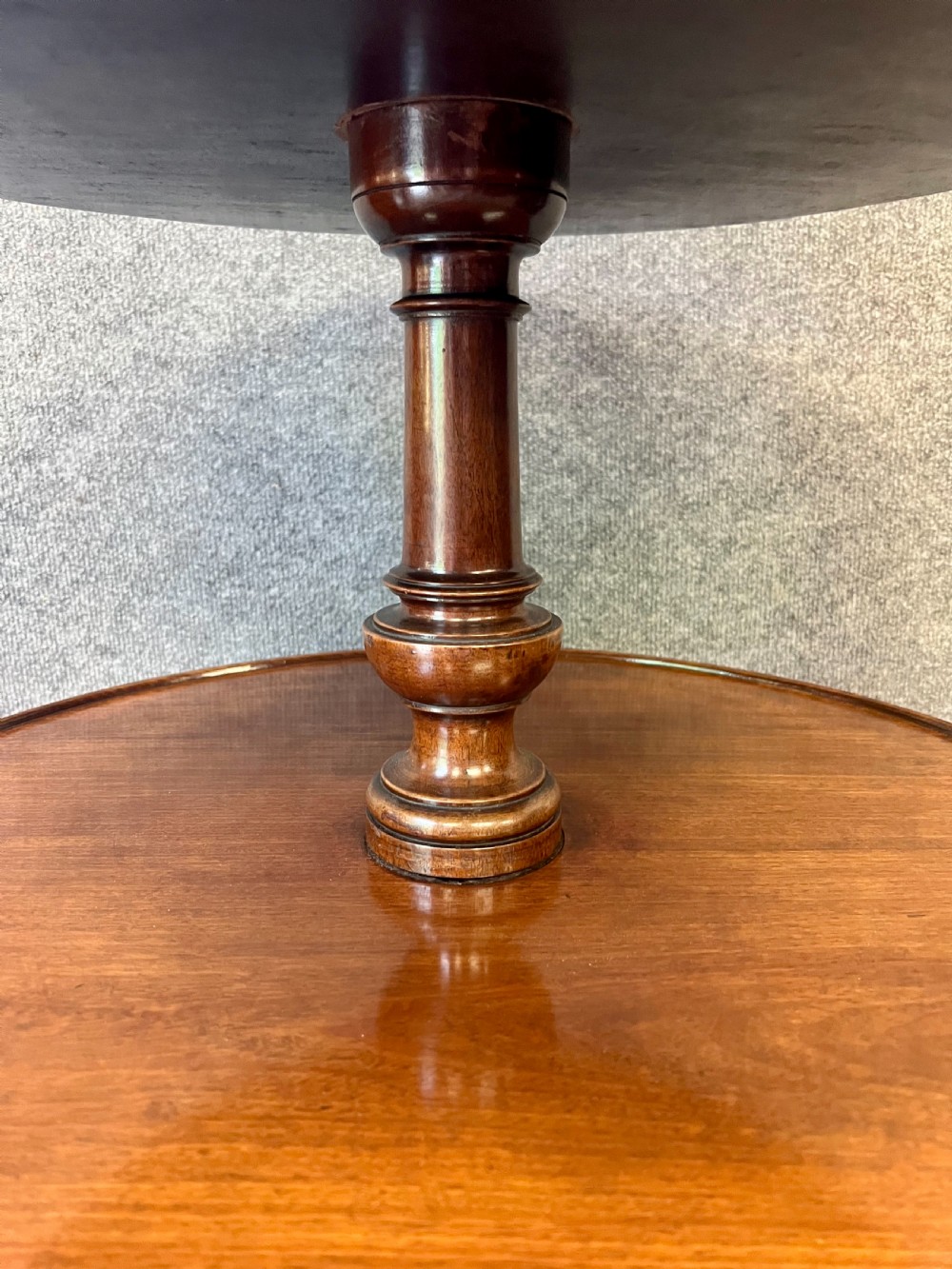 A George III mahogany three-tiered dumbwaiter table with turned central columns, graduated circular surfaces, and a tripod base with pad feet. View IV