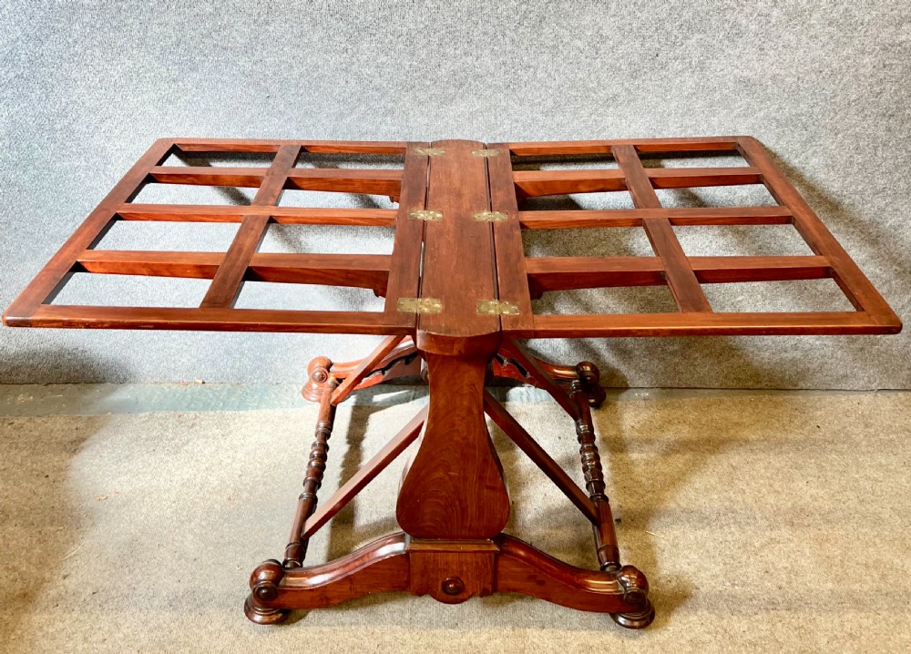 A George IV mahogany folio stand with hinged slatted frames, turned stretchers, and carved scrolled feet. View II
