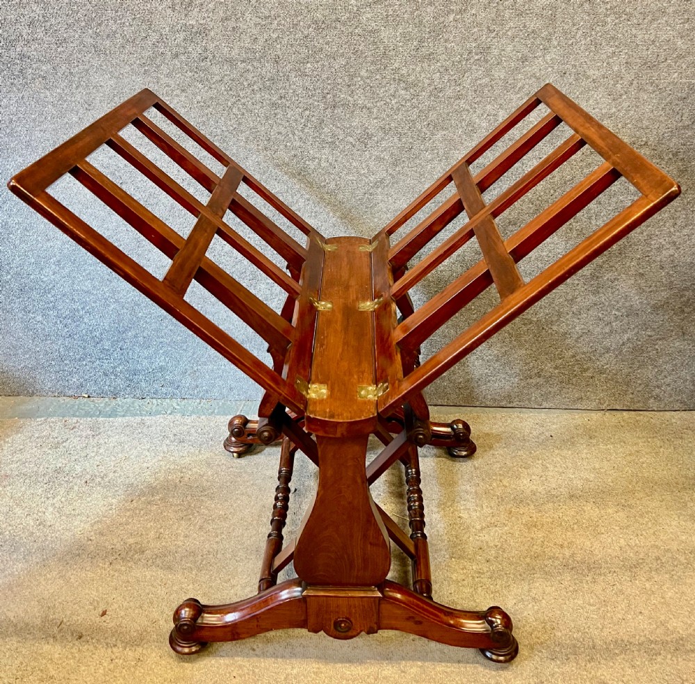 A George IV mahogany folio stand with hinged slatted frames, turned stretchers, and carved scrolled feet. View IV