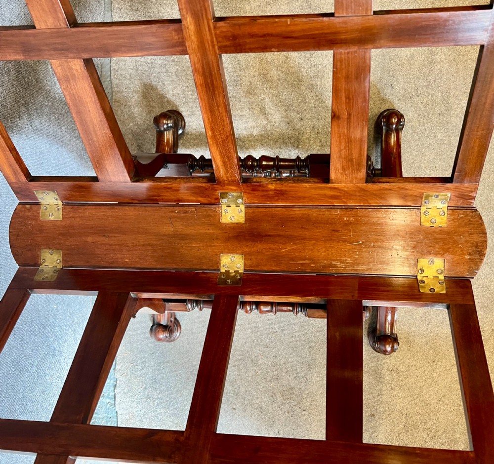 A George IV mahogany folio stand with hinged slatted frames, turned stretchers, and carved scrolled feet. View VI