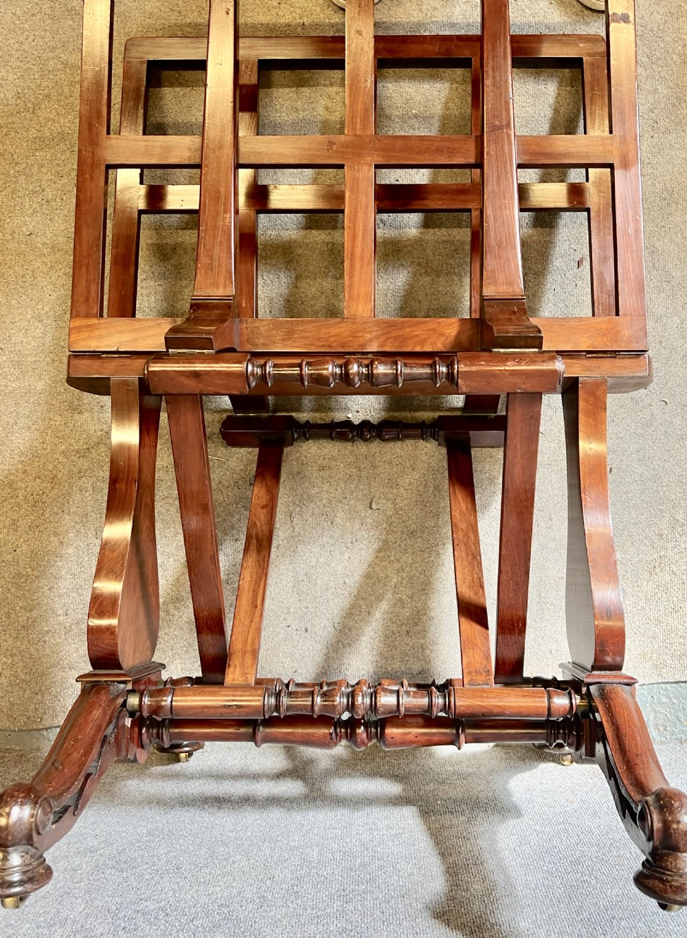 A George IV mahogany folio stand with hinged slatted frames, turned stretchers, and carved scrolled feet. View VIII