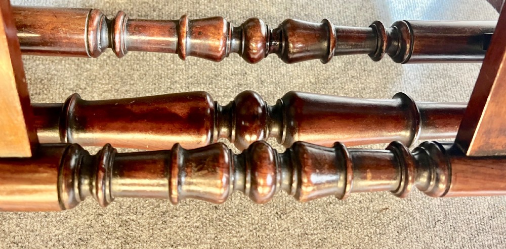 A George IV mahogany folio stand with hinged slatted frames, turned stretchers, and carved scrolled feet. View X