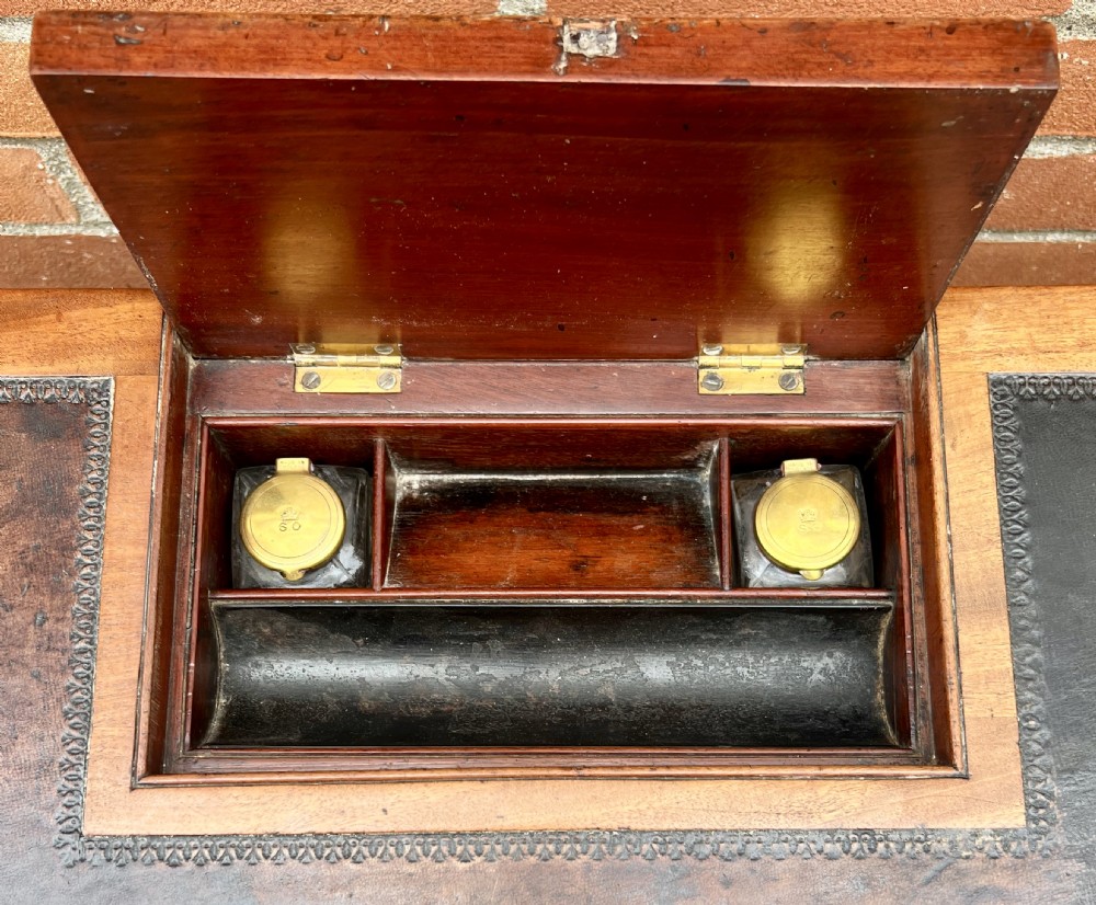 A Regency mahogany chamber writing table featuring a leather-inset surface, single long drawer, turned wooden knobs, and reeded legs on brass castors. View III