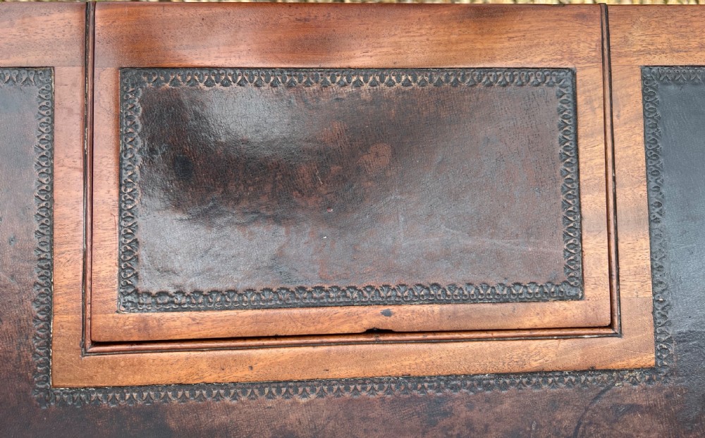 A Regency mahogany chamber writing table featuring a leather-inset surface, single long drawer, turned wooden knobs, and reeded legs on brass castors. View XII