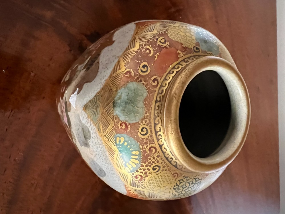 A small Japanese Satsuma earthenware vase featuring hand-painted figures, landscape scenes, geometric gold patterns, and a crackled cream glaze. View VI