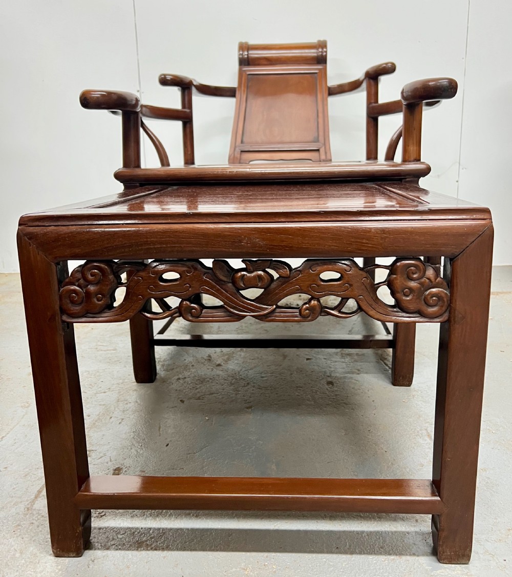 A Chinese polished dark hardwood stargazer chair featuring curved armrests, a raised cylindrical headrest, and an extendable carved footrest. View II