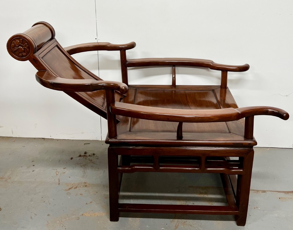A Chinese polished dark hardwood stargazer chair featuring curved armrests, a raised cylindrical headrest, and an extendable carved footrest. View III