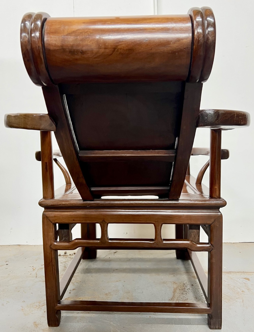 A Chinese polished dark hardwood stargazer chair featuring curved armrests, a raised cylindrical headrest, and an extendable carved footrest. View VIII