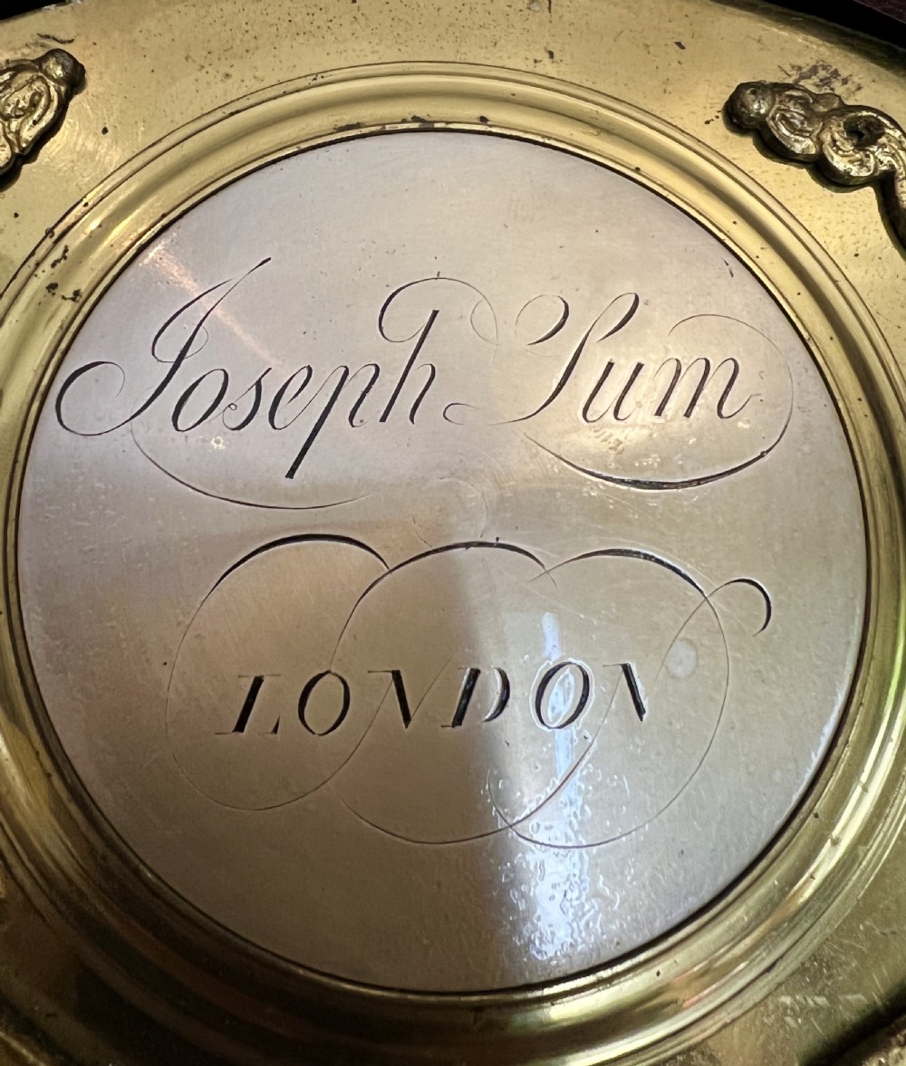 A George III mahogany longcase clock featuring an inlaid trunk door, brass eagle finials, fluted columns, and a brass dial with silvered chapter ring. View VI