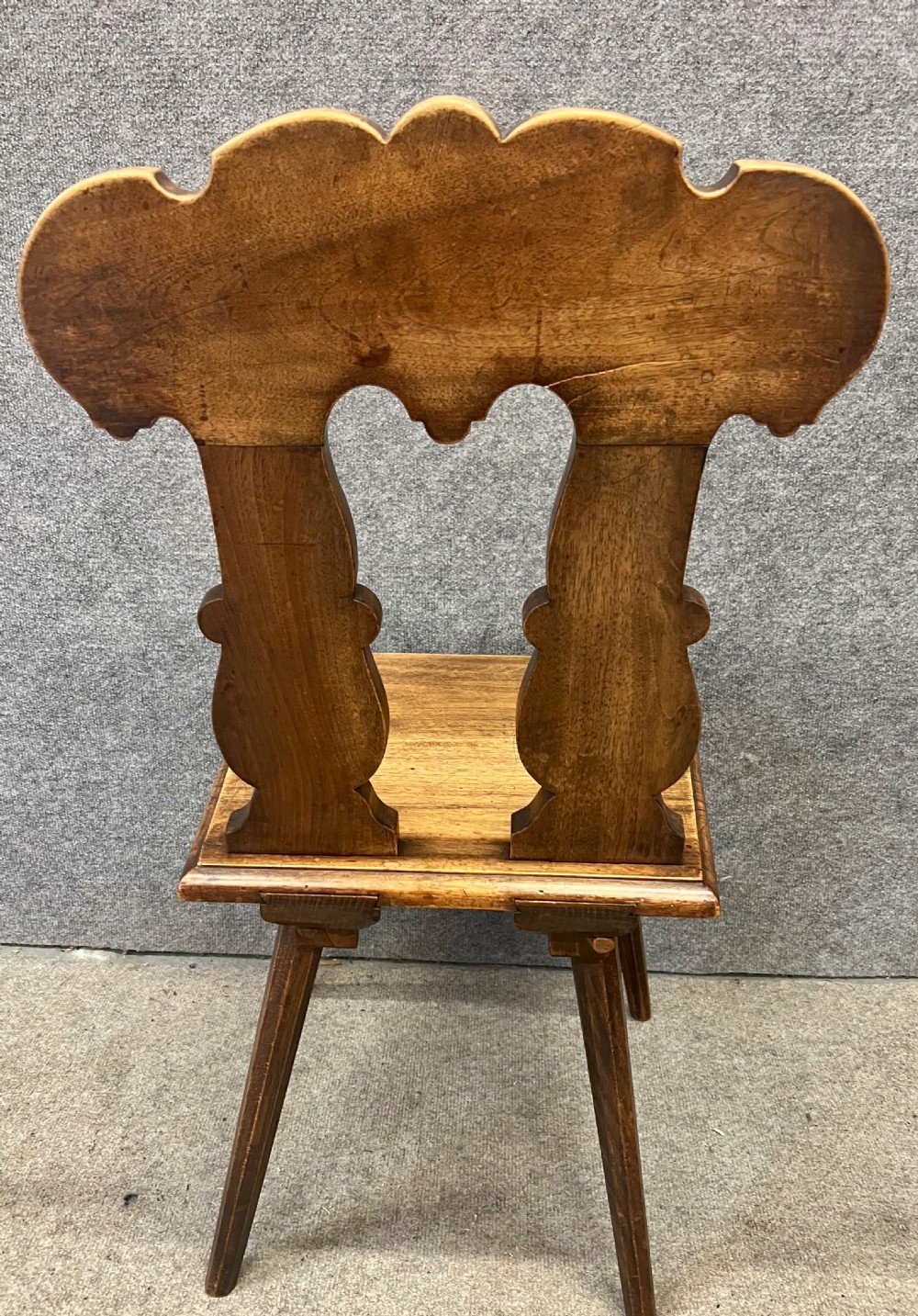 A set of four carved timber Swiss Alpine escabelle chairs featuring detailed scrollwork and heart motifs on the backrests with splayed tapered legs. View VIII
