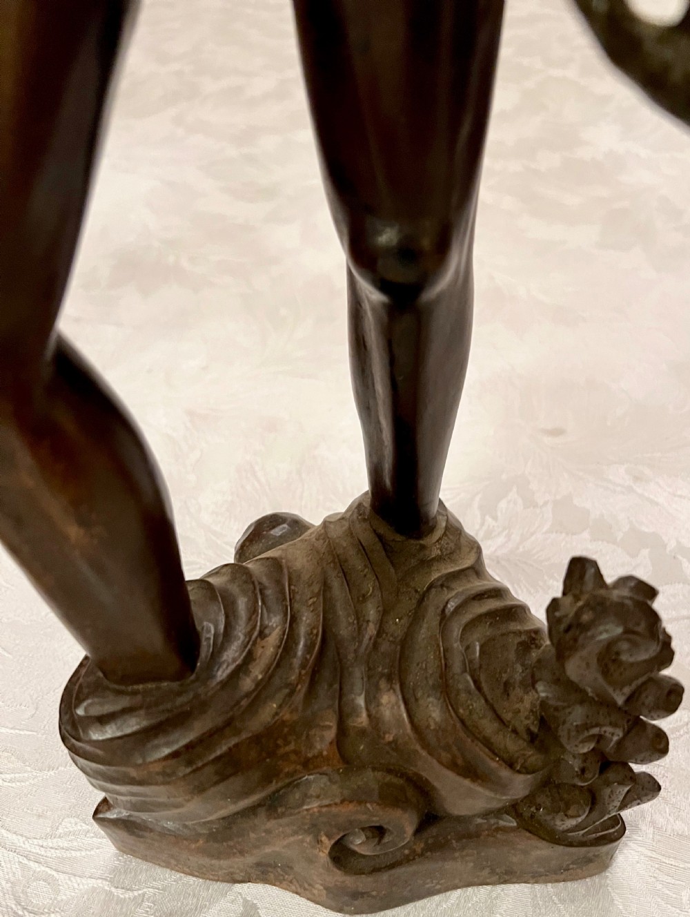 A hand-carved dark hardwood sculpture of a Chinese fisherman holding a net and basket on a stylised wave base. View V