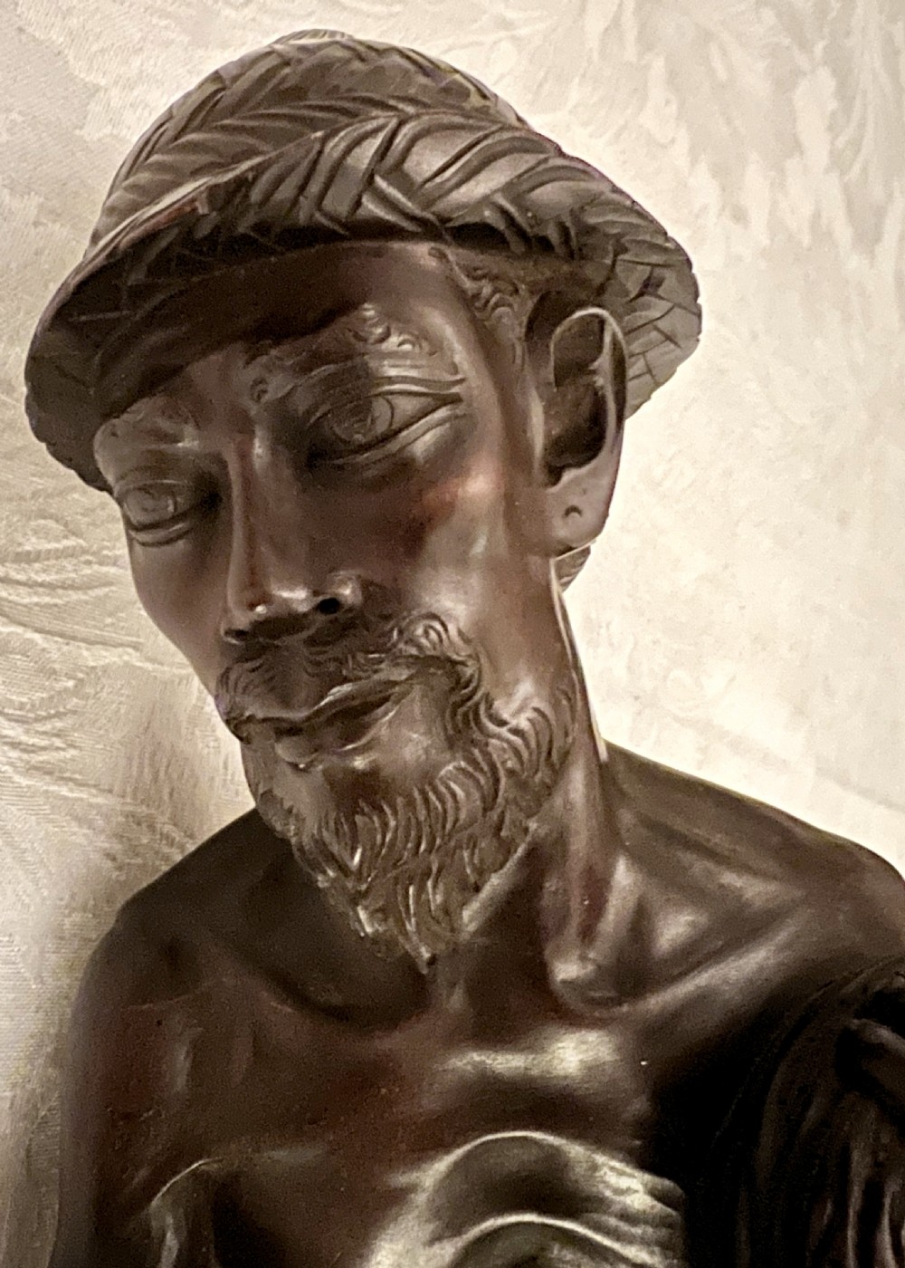 A hand-carved dark hardwood sculpture of a Chinese fisherman holding a net and basket on a stylised wave base. View VIII