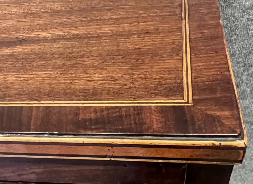 A George III mahogany chest of drawers featuring three graduated drawers with brass oval handles and line inlay on shaped bracket feet. View IV