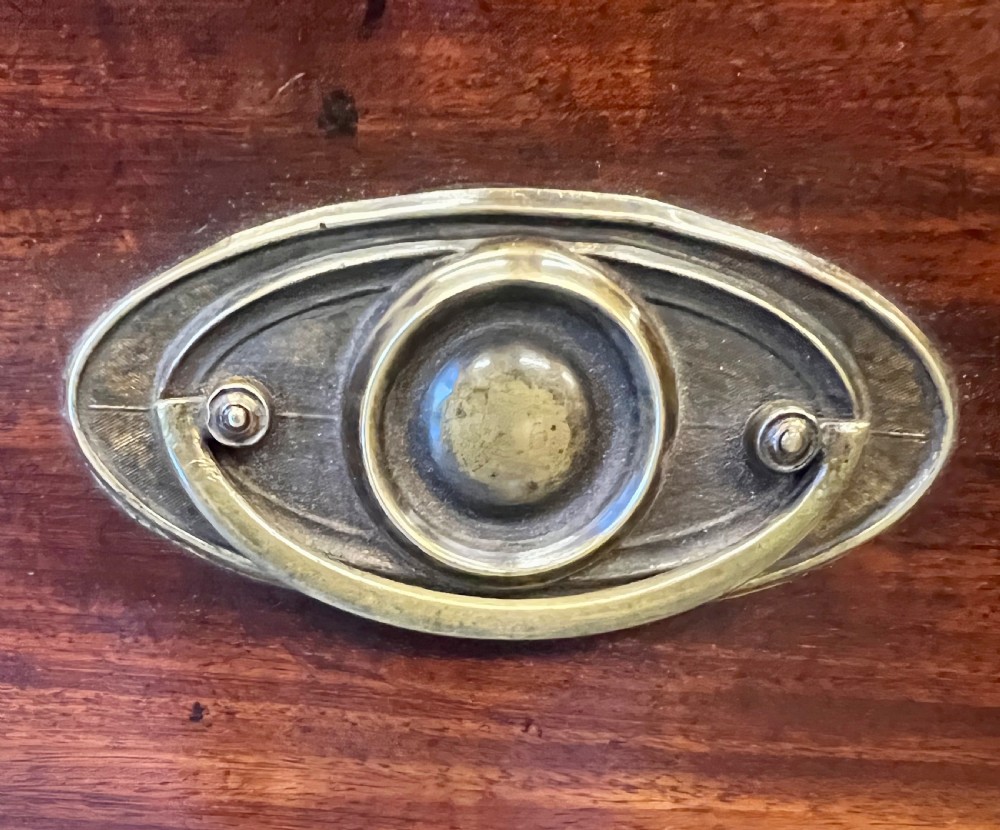 A George III mahogany chest of drawers featuring three graduated drawers with brass oval handles and line inlay on shaped bracket feet. View VI