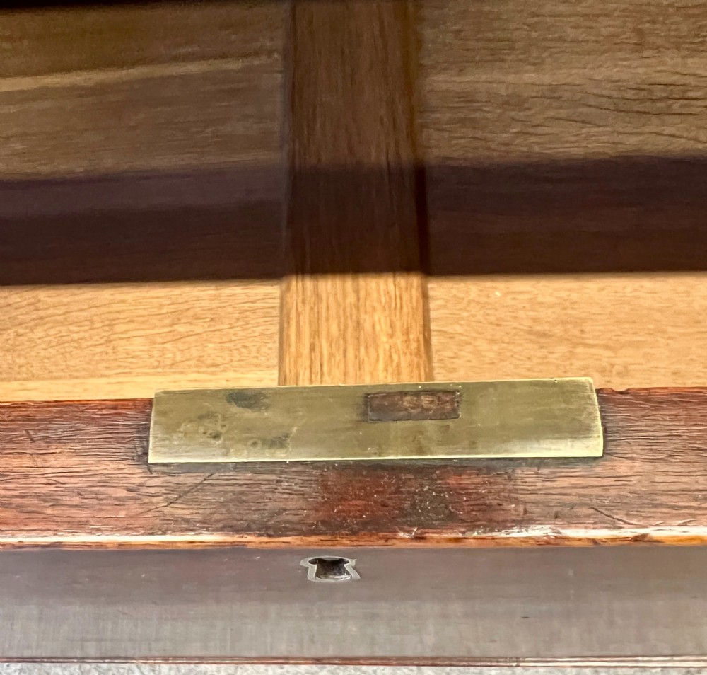 A George III mahogany chest of drawers featuring three graduated drawers with brass oval handles and line inlay on shaped bracket feet. View VII