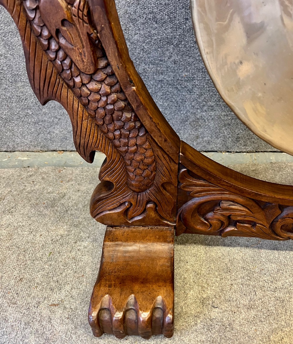 A hand-carved dark wood circular gong stand featuring twin dragon motifs and claw feet, suspending a central brass gong with a red textile mallet below. View IV