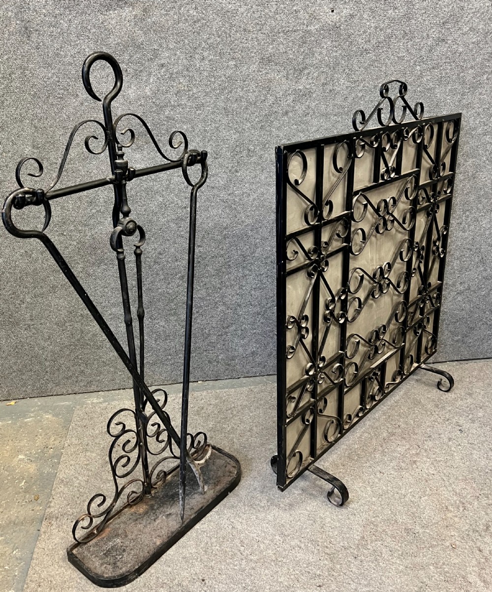 A wrought iron fire screen featuring decorative scrollwork alongside a matching companion set stand with fire tools. View IV