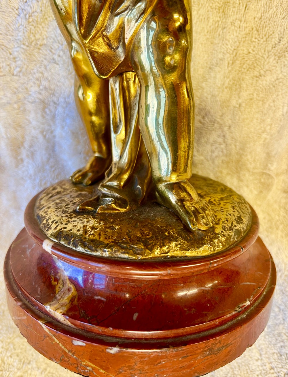 A gilt bronze sculpture depicting a young girl holding a woven basket on a circular red marble base. View VII