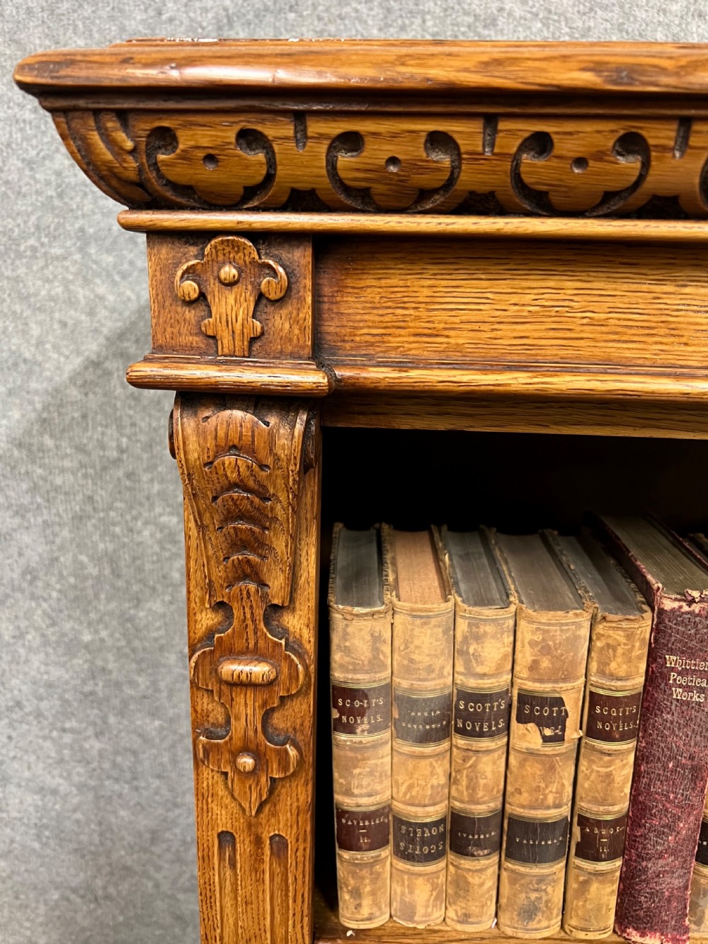 A pair of low oak open bookcases featuring raised central plinths, rope-twist columns, and intricately carved relief strapwork panels. View VI