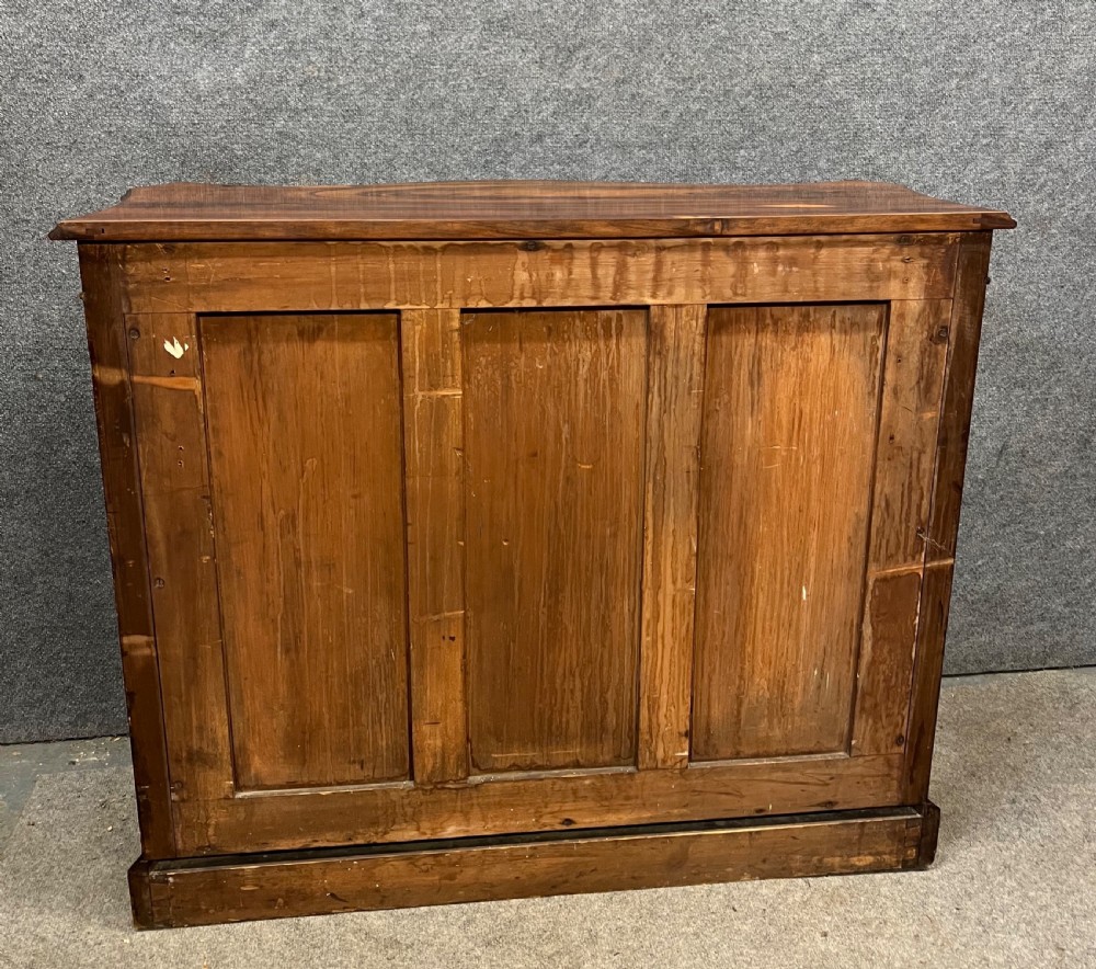 A low nineteenth-century open bookcase crafted from Goncalo Alves wood, featuring serpentine front shelves and carved acanthus leaf corbels. View IX
